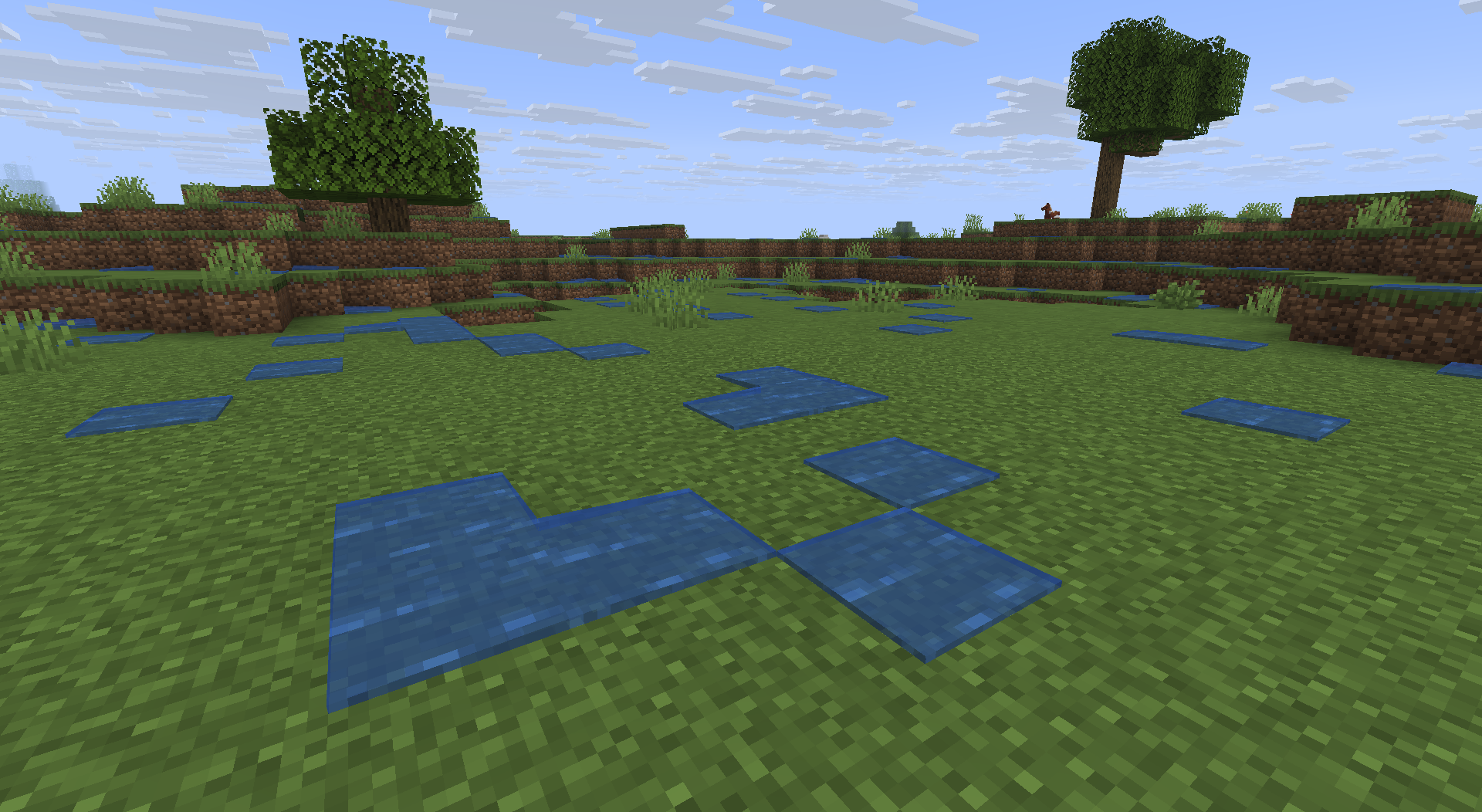 Puddles scattered around a plains biome, with a large tree in the background and a smaller one slightly closer. The puddles look similar to flowing water, but are static. They are scattered mostly randomly, but mostly in clusters.